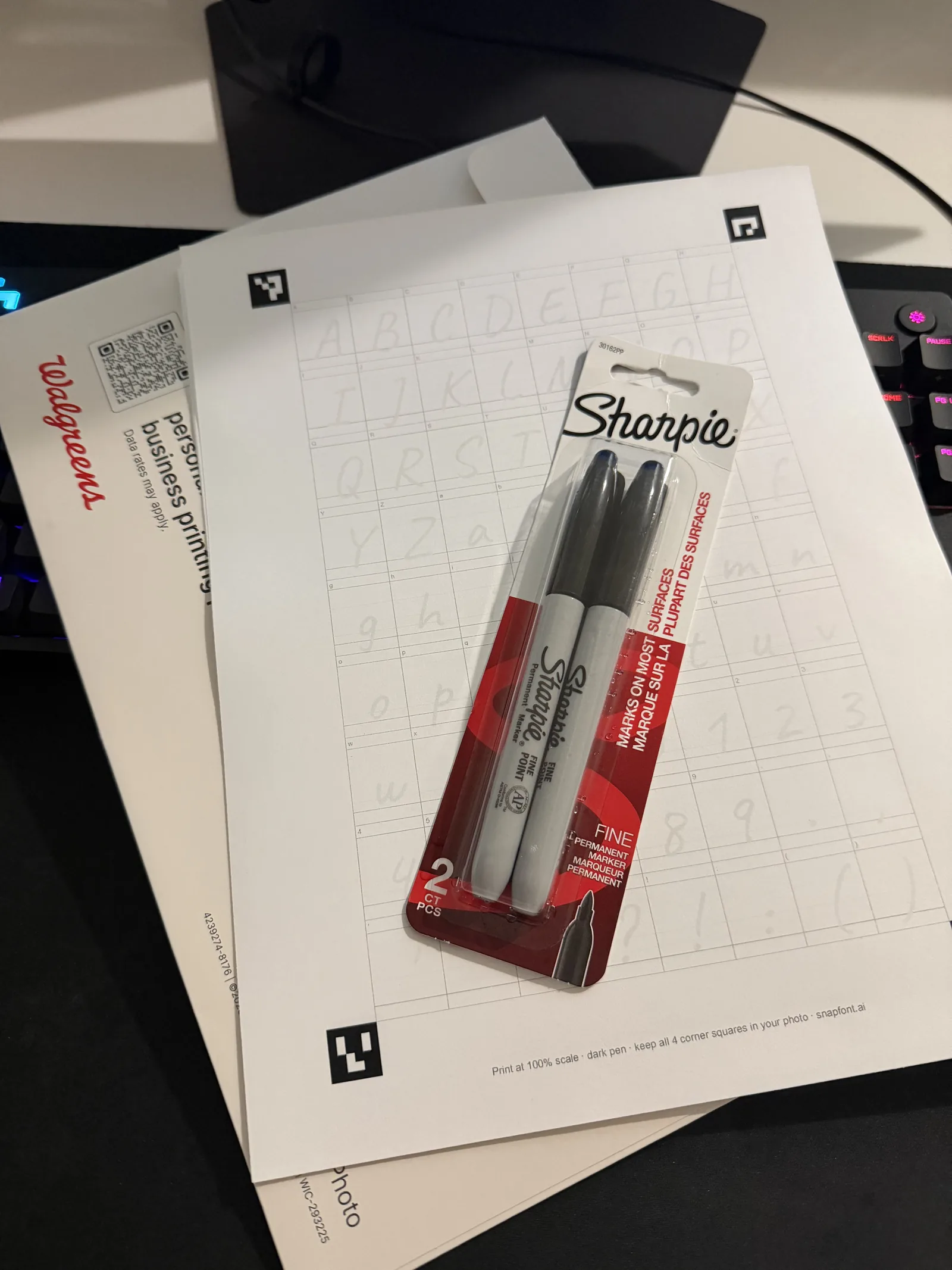 The SnapFont template sheet printed at a Walgreens photo counter, with a pack of two fine point Sharpies on top